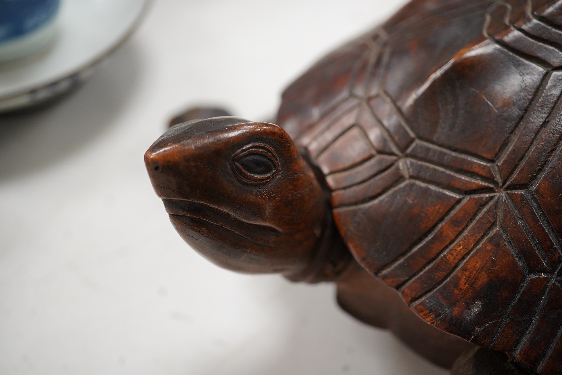 A late 19th century/early 20th century carved walnut box in the form of a tortoise, the shell opening to reveal a compartment, 29cm wide. Condition - fair, tail re-glued